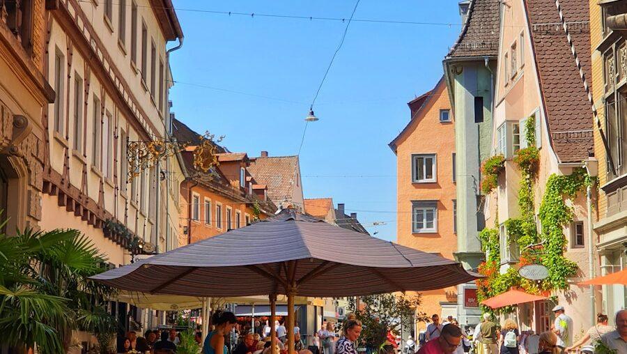 a group of people sitting at tables in a city