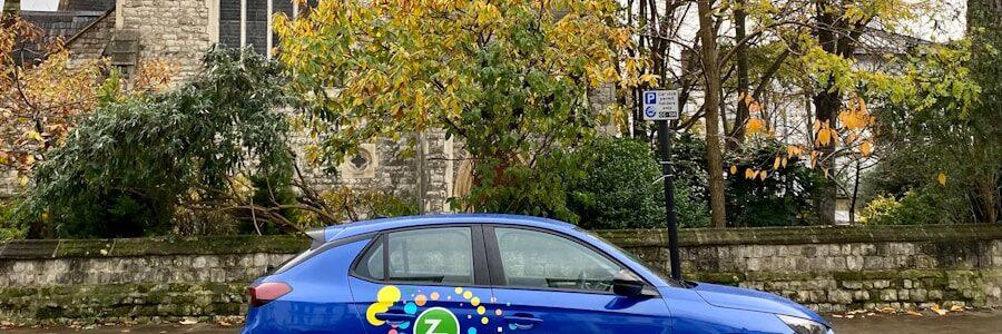 a blue car parked in front of a church