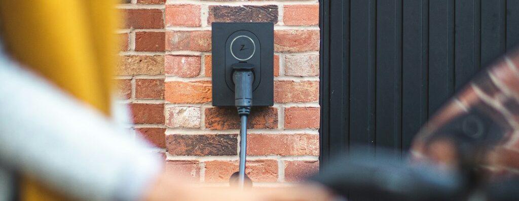 a woman is charging her bike with a charger