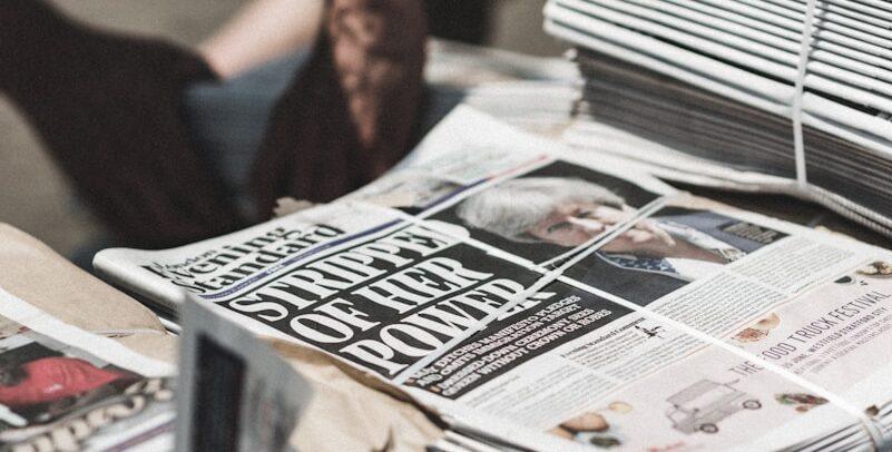 shallow focus photography of piles of newspapers